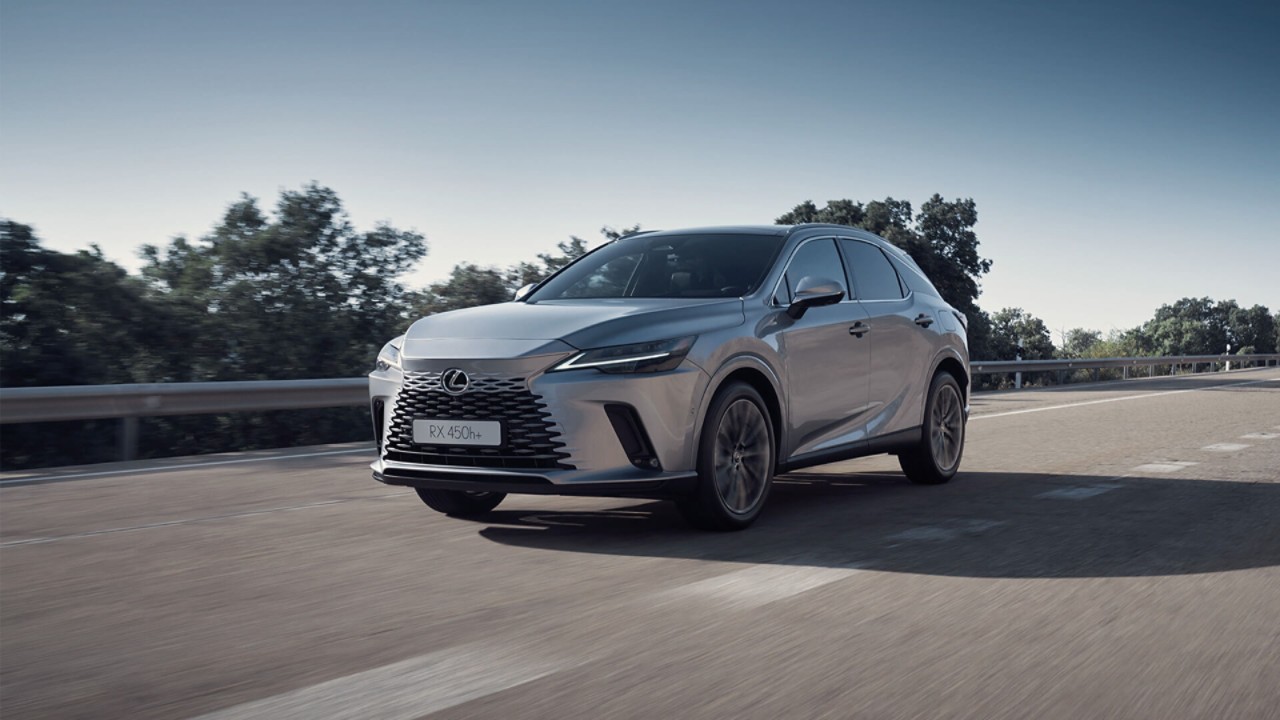 A Lexus NX 450h+ plugged into a charging station outside a home