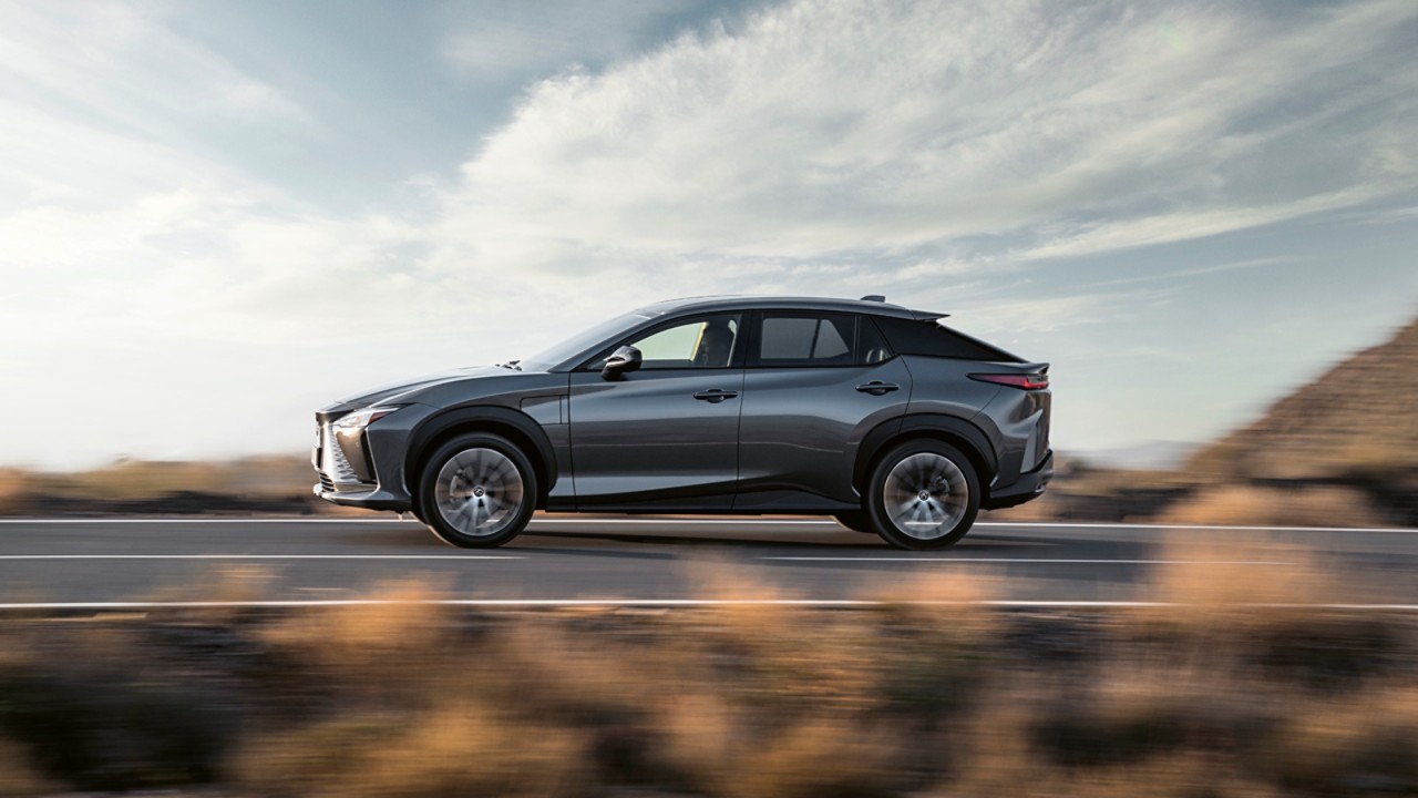 Side view of the Lexus RZ 450e driving on a road