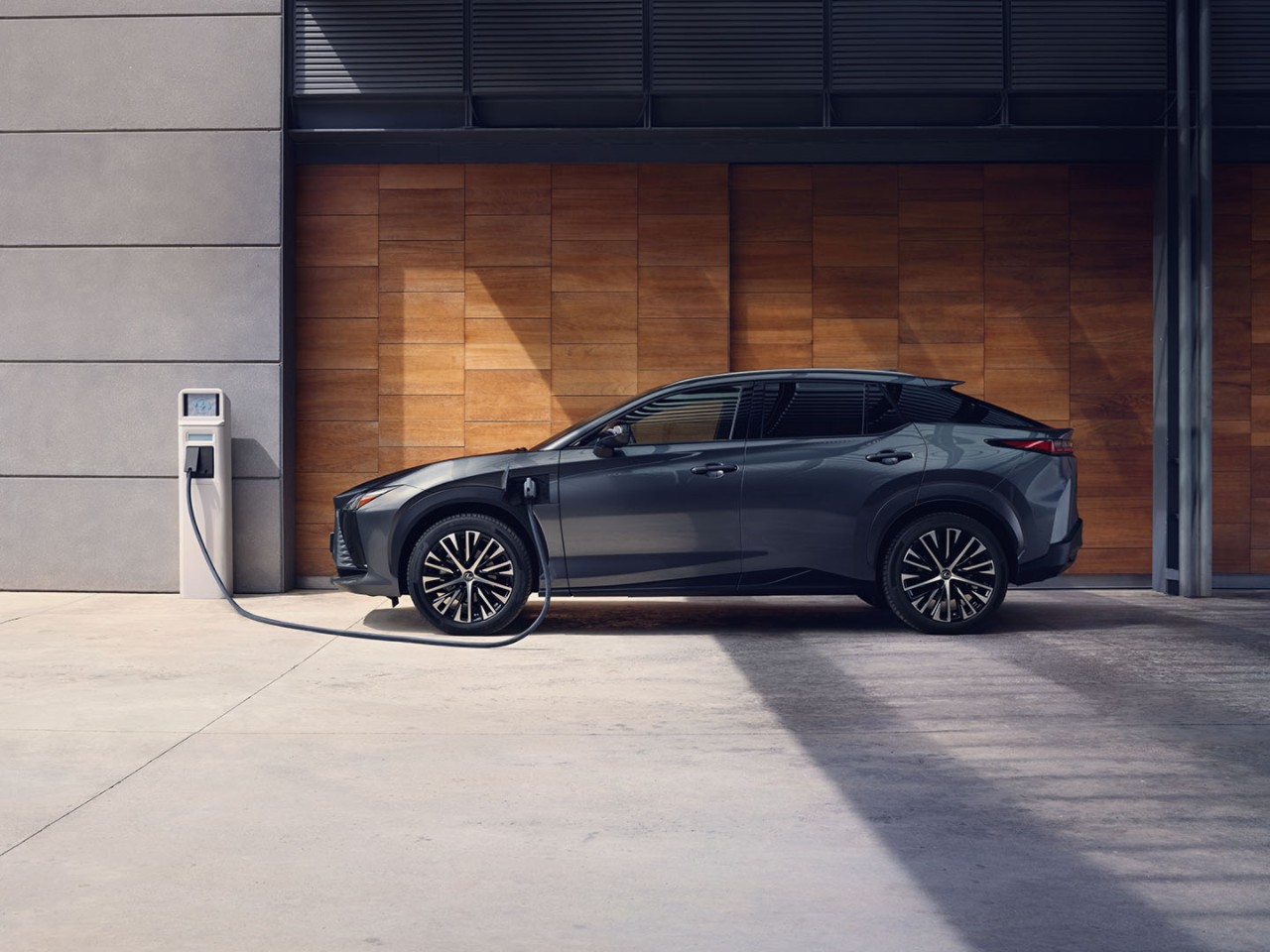 A man plugging in a home socket into a Lexus UX 300e