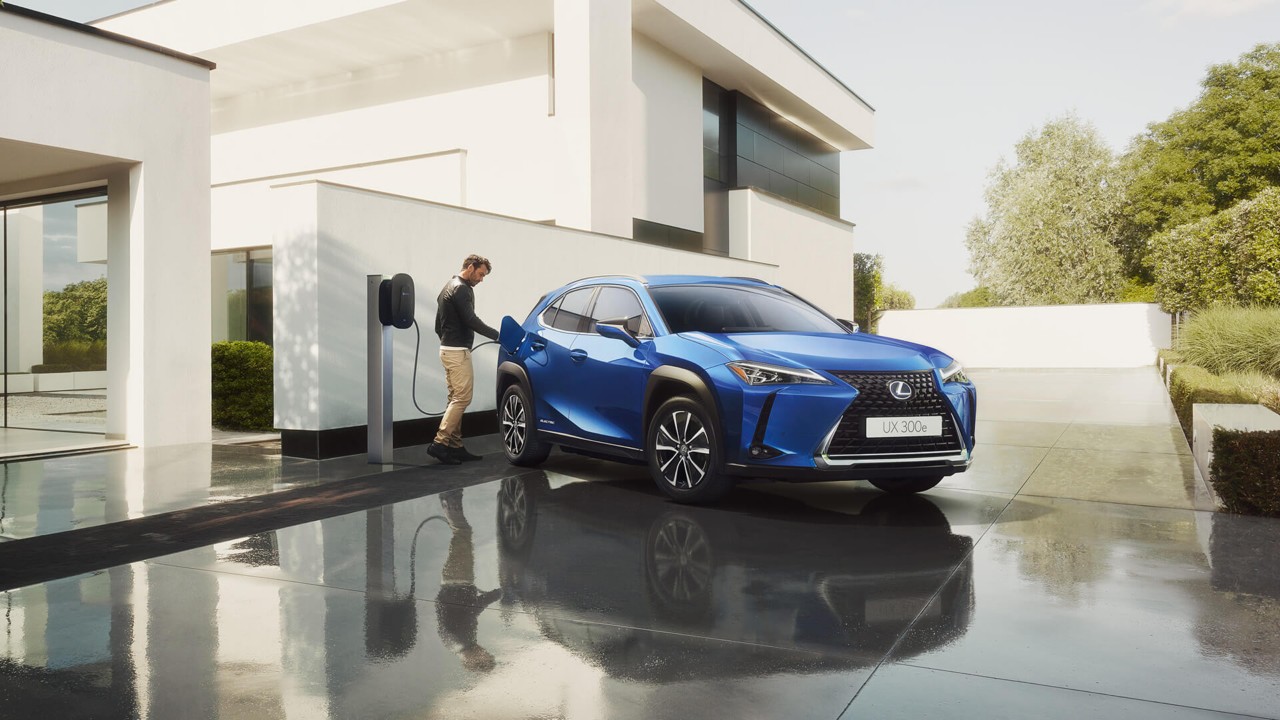 A man plugging in a charger into a Lexus UX 300e