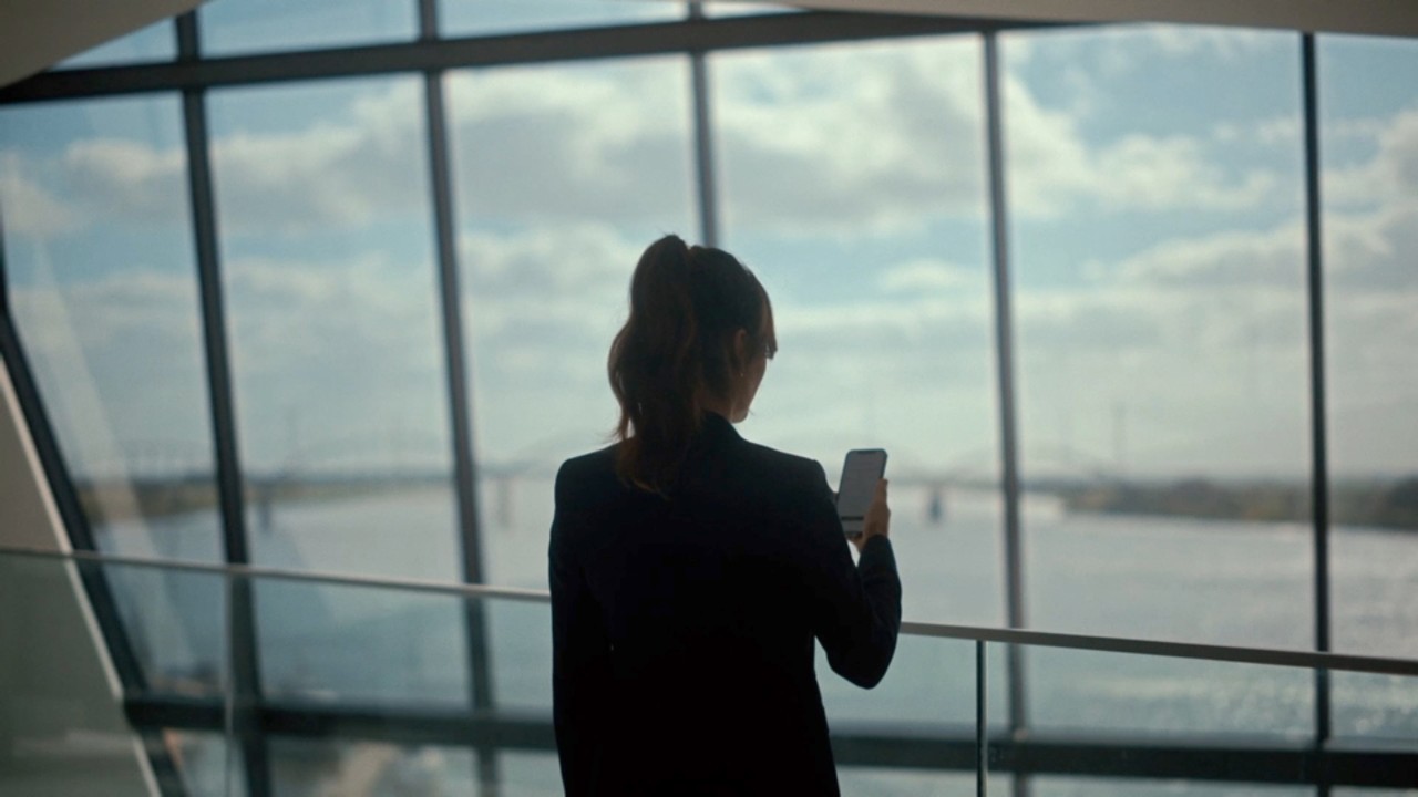 A person looking at their phone near a window